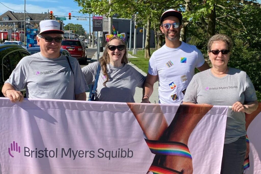 Photo of BMS employees walking with a banner in a pride parade
