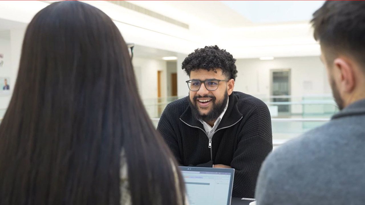 Photo of Omar talking with colleagues