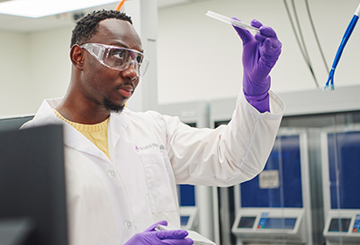 Photo of scientist looking at a test tube